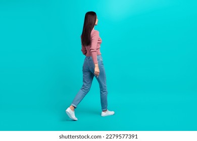 Full length profile portrait of walking young person look empty space isolated on turquoise color background