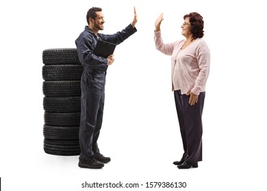 Full Length Profile Shot Of An Auto Mechanic Gesturing High-five With A Mature Woman Isolated On White Background