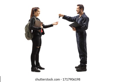 Full length profile shot of an auto mechanic giving car keys to a young female isolated on white background - Powered by Shutterstock