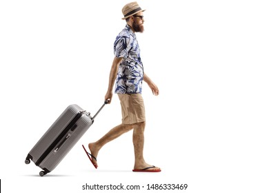 Full length profile shot of a bearded man with a suitcase walking isolated on white background