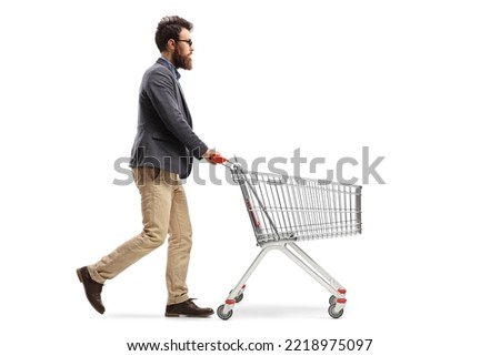 Full length profile shot of a bearded man pushing a shopping cart isolated on white background