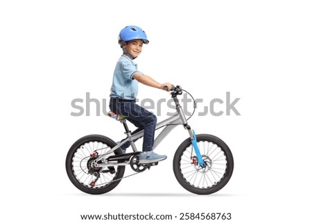 Full length profile shot of a boy with a helmet riding a bicycle  isolated on white background