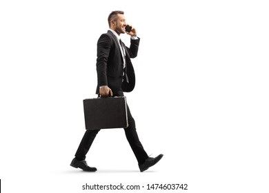 Full length profile shot of a businessman walking and talking on a mobile phone isolated on white background - Powered by Shutterstock