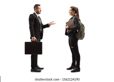 Full length profile shot of a businessman talking to a girl with a backpack and a book isolated on white background