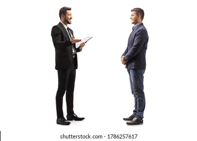 Full Length Profile Shot Of A Businessman Holding A Clipboard And Talking To A Man Isolated On White Background