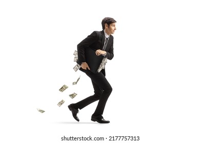 Full length profile shot of a businessman running and holding a briefcase full of money isolated on white background