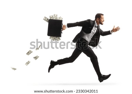 Full length profile shot of a businessman running fast and carrying a briefcase with money isolated on white background