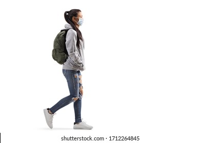 Full Length Profile Shot Of A Casual Female Student Wearing A Protective Medical Mask And Walking Isolated On White Background