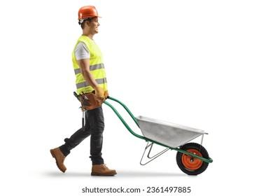 Full length profile shot of a construction worker pushing a wheelbarrow isolated on white background