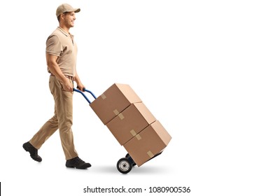 Full Length Profile Shot Of A Delivery Guy Pushing A Hand Truck With Boxes Isolated On White Background