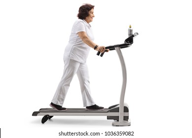 Full Length Profile Shot Of An Elderly Woman Walking On A Treadmill Isolated On White Background