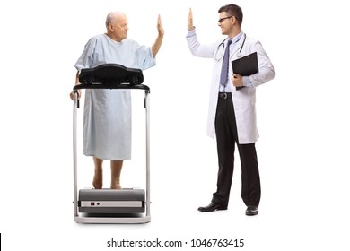 Full Length Profile Shot Of An Elderly Patient Walking On A Treadmill And High-fiving A Doctor Isolated On White Background