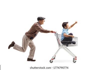 Full length profile shot of an elderly man running and pushing a shopping cart with a boy inside isolated on white background - Powered by Shutterstock