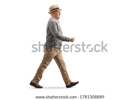 Full length profile shot of an elderly gentleman walking isolated on white background