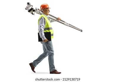 Full Length Profile Shot Of An Engineer Walking And Carrying Measuring Instrument Isolated On White Background