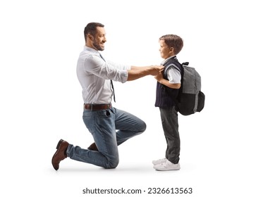 Full length profile shot of a father helping his son getting ready for school isolated on white background
