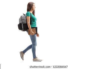 Full length profile shot of a female student with backpack walking isolated on white background - Powered by Shutterstock