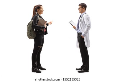 Full Length Profile Shot Of A Female Teenager Talking To A Male Doctor Isolated On White Background