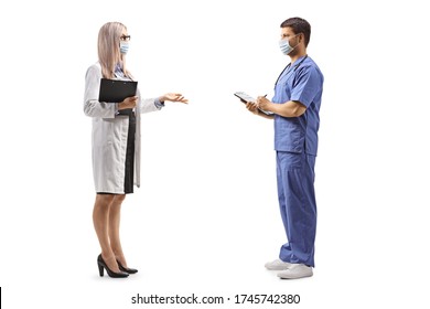 Full Length Profile Shot Of A Female Doctor With A Protective Mask Talking To A Male Nurse Isolated On White Background