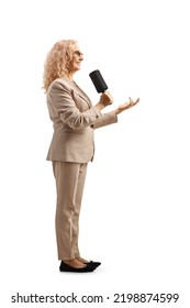 Full Length Profile Shot Of A Female Tv Presenter With A Microphone Isolated On White Background