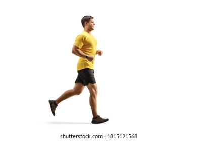 Full length profile shot of a fit man in a yellow t-shirt and black shorts running isolated on white background