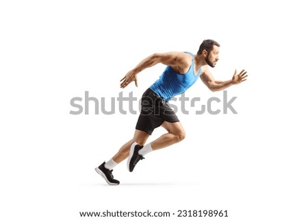 Full length profile shot of a fit male athlete running fast isolated on white background