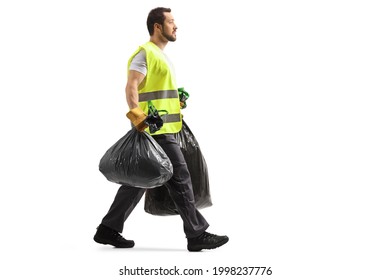 Full Length Profile Shot Of A Garbage Man Walking And Carrying Bin Bags Isolated On White Background