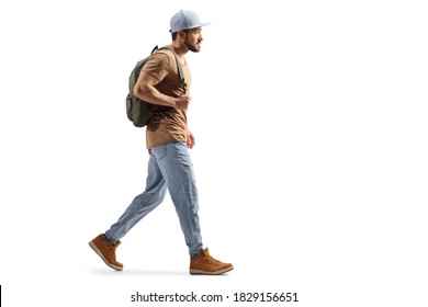 Full Length Profile Shot Of A Guy With A Backpack And Ripped Jeans Walking Isolated On White Background