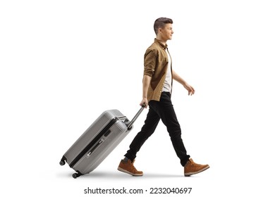 Full length profile shot of a guy walking and pulling a suitcase isolated on white background - Shutterstock ID 2232040697