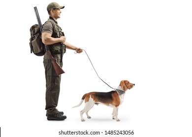 Full length profile shot of a hunter standing with a rifle and a beagle dog on a leash isolated on white background