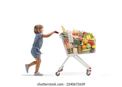 Full length profile shot of a little girl pushing a big shopping cart isolated on white background