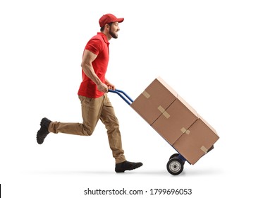 Full Length Profile Shot Of A Male Worker Running With Boxes On A Hand-truck Isolated On White Background