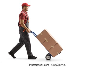 Full Length Profile Shot Of A Male Worker Pushing Boxes On A Hand-truck Isolated On White Background