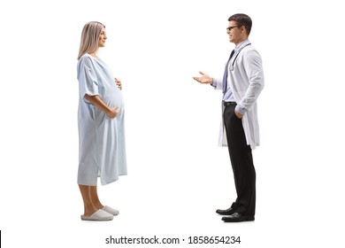 Full Length Profile Shot Of A Male Doctor Talking To A Pregnant Woman Patient In A Hospital Gown Isolated On White Background