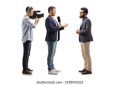 Full Length Profile Shot Of A Male Reporter With A Microphone And A Cameraman Interviewing A Man Isolated On White Background