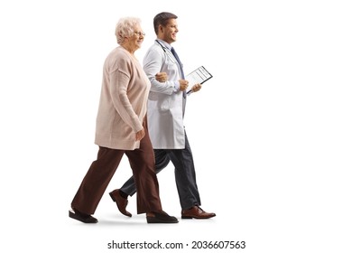 Full Length Profile Shot Of A Male Doctor Walking With An Elderly Woman Isolated On White Background