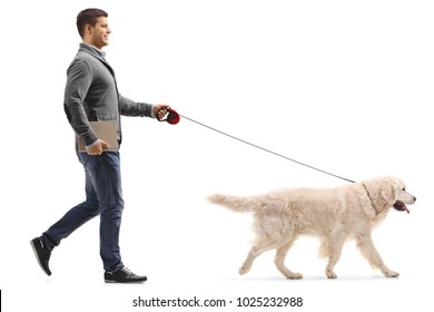 Full Length Profile Shot Of A Man With A Book Walking A Dog Isolated On White Background