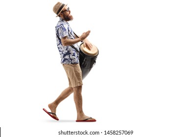 Full length profile shot of a man walking and playing conga drums isolated on white background - Powered by Shutterstock