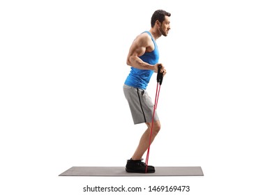 Full Length Profile Shot Of A Man On An Exercise Mat With A Resistance Band Isolated On White Background