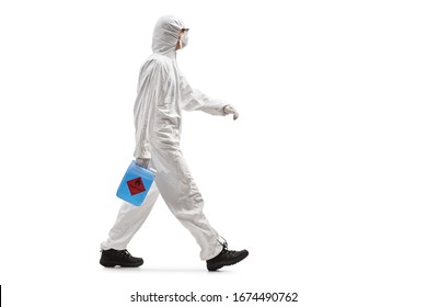 Full length profile shot of a man in a hazmat suit holding a disinfecant gel and walking isolated on white background