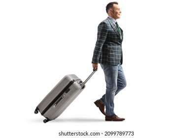 Full Length Profile Shot Of A Man In Suit And Jeans Walking And Pulling A Suitcase Isolated On White Background