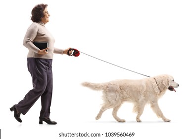 Full Length Profile Shot Of A Mature Woman Walking A Dog Isolated On White Background