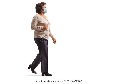 Full Length Profile Shot Of A Mature Woman Walking And Wearing A Protective Medical Face Mask Isolated On White Background