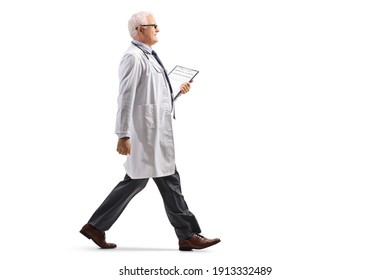 Full Length Profile Shot Of A Mature Doctor Walking Isolated On White Background