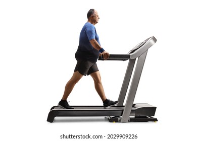 Full length profile shot of a mature man walking on a treadmill isolated on white background - Powered by Shutterstock