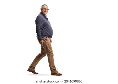 Full Length Profile Shot Of A Mature Smiling Man Walking Isolated On White Background