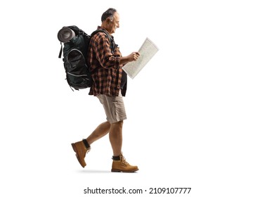 Full length profile shot of a mature hiker reading a map and walking isolated on white background - Powered by Shutterstock