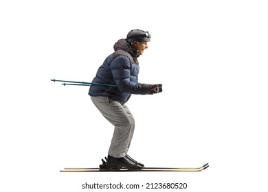 Full length profile shot of a mature man on skiis isolated on white background