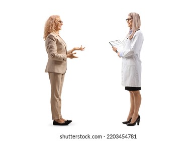 Full Length Profile Shot Of A Mature Female Patient And A Female Doctor Having A Conversation Isolated On White Background