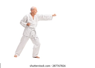 Full Length Profile Shot Of An Old Man In A White Kimono Practicing Karate Isolated On White Background 